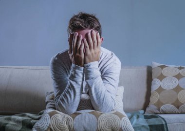 ev yaşam oturan genç üzgün ve umutsuz adam kafa ile depresyon ve stres el ele tutuşarak koltuk kanepe endişeli sorun yalnız üzüntü ve yaşam tarzı kavramı hakkında ağlıyor