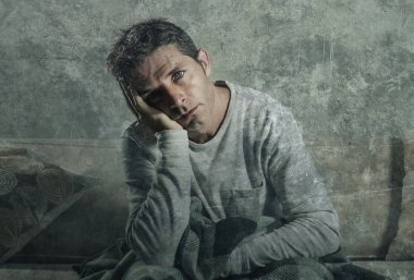 Genç üzgün ve umutsuz adam evde acı depresyon kanepe oturma kanepe oturma ve duygu sefil hayal kırıklığı kavramı ve yaşam tarzı kavramı sert grunge arka planda stres