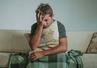 yaşam kanepe evde oturan genç üzgün ve umutsuz adam kanepede holding yastık depresyon ve stres depresyon yaşam tarzı kavramında sefil duygu sorun hakkında endişeli