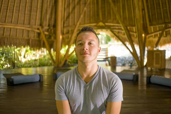 Jovem atraente e feliz homem fazendo ioga sentado em posição de lótus meditando relaxado em harmonia na bela cabana de bambu asiático apreciando a natureza no corpo e equilíbrio mental — Fotografia de Stock