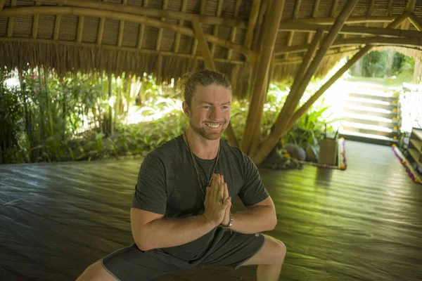 Homem feliz no estilo hipster yogi fazendo ioga broca na bela cabana de bambu asiático em namaste mãos posição apreciando a natureza no equilíbrio da mente do corpo e boas vibrações — Fotografia de Stock