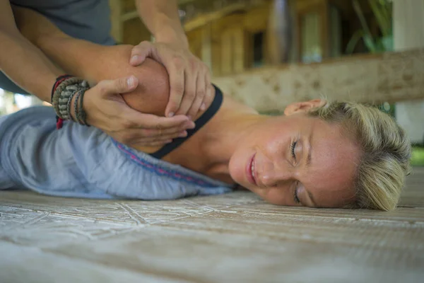 Junge schöne und glückliche amerikanische Touristin mit traditionellen thailändischen Massage in ihrem Körper von asiatischen Masseur im Outdoor-Spa genießen Urlaub Rückzug — Stockfoto