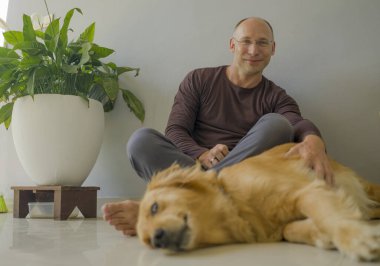Genç, mutlu ve neşeli bir adam köpeğiyle oynuyor, güzel bir av köpeği, sevimli bir gülümseme ile evcil hayvana sarılıyor ve bağ kuruyor.