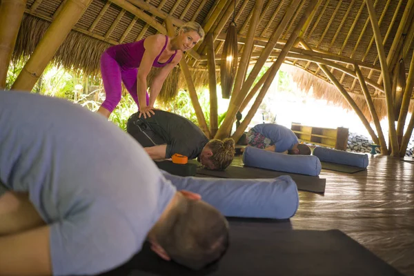 Lección de yoga al aire libre - grupo de jóvenes y entrenadoras que practican ejercicio de relajación en el refugio de bienestar asiático, entrenamiento en cabaña, equilibrio corporal y mental juntos — Foto de Stock