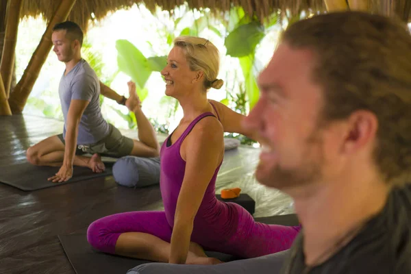 Lección de yoga al aire libre - grupo de jóvenes y entrenadoras que practican ejercicio de relajación en el refugio de bienestar asiático, entrenamiento en cabaña, equilibrio corporal y mental juntos —  Fotos de Stock