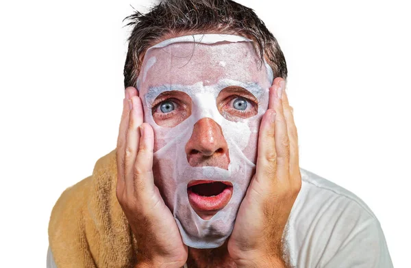 Styl życia odizolowany tło portret młodego dziwnego i zabawnego człowieka w domu próbuje przy użyciu papierowej maski oczyszczającej twarzy stosując anti aging leczenia urody — Zdjęcie stockowe