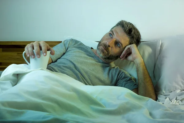 Młody smutny i przygnębiony mężczyzna leżący przemyślany i zamyślony na łóżku odwracając wzrok czując się zagubionym myśląc cierpiąc jakiś problem w smutku emocji i koncepcji depresji — Zdjęcie stockowe
