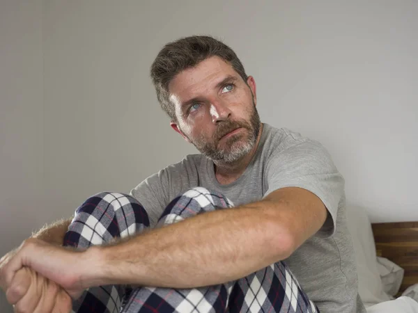 Joven hombre triste y deprimido acostado reflexivo y pensativo en la cama mirando hacia otro lado sintiéndose perdido pensando que sufre algún problema en tristeza emoción y depresión concepto — Foto de Stock