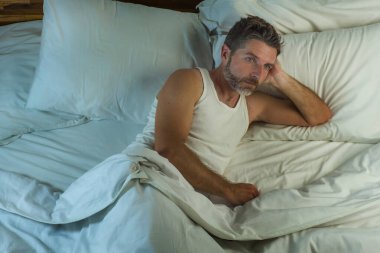 Genç, çekici, üzgün ve depresif bir adamın dramatik yaşam tarzı portresi. Geceleri yatakta yatarken stresli bir depresyon, hüzün ve melankolik sorunları yaşadığını düşünüyor. 