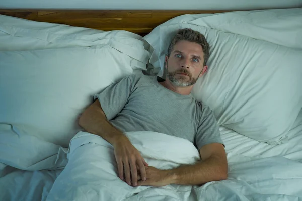 Estilo de vida doméstico alto ángulo retrato de joven hombre guapo despierto por la noche con los ojos azules bien abiertos incapaces de dormir sufriendo insomnio trastorno del sueño estresado e inquieto — Foto de Stock