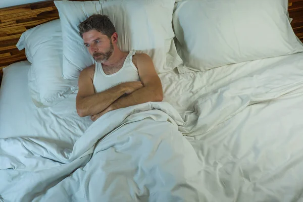 Dramático estilo de vida retrato de joven atractivo triste y deprimido hombre acostado en la cama despierto pensamiento por la noche sensación de estrés sufrimiento depresión problema en la tristeza y la melancolía — Foto de Stock