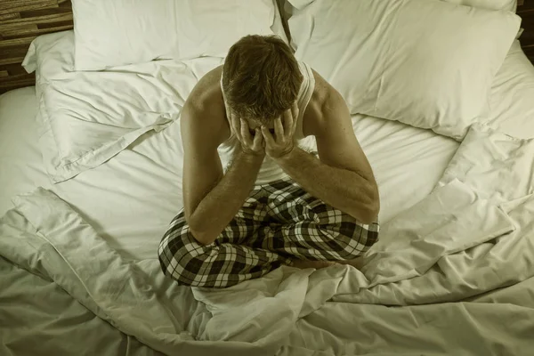 Drámai életmód portré fiatal vonzó szomorú és depressziós férfi ül az ágyon éjszaka érzés stresszes és kétségbeesett szenvedés depresszió probléma szomorúság és fájdalom — Stock Fotó