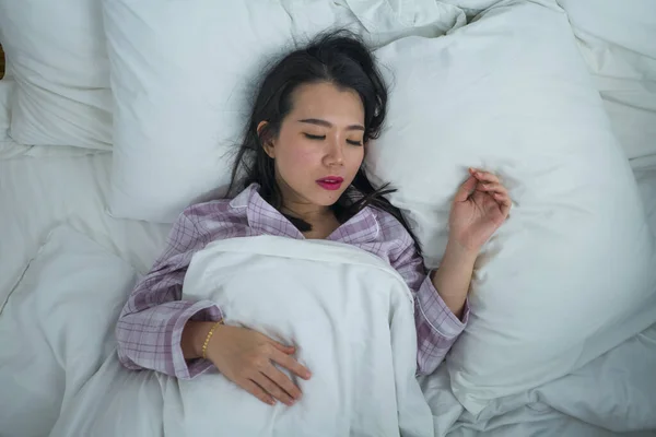 Potret gaya hidup gadis Cina Asia yang cantik dan manis berusia 20-an sendirian di rumah tidur santai mengenakan piyama berbaring di tempat tidur bahagia dan nyaman beristirahat — Stok Foto