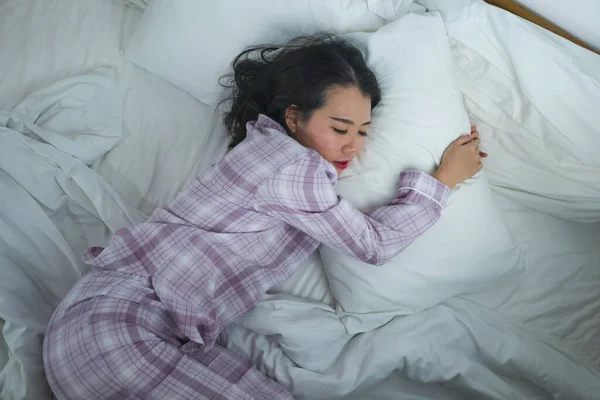 Estilo de vida retrato de joven hermosa y dulce chica china asiática en sus años 20 solo en casa durmiendo relajado usando pijamas acostado en la cama feliz y cómodo descanso — Foto de Stock