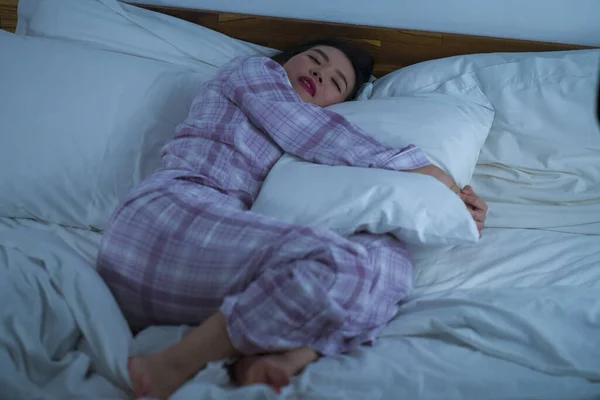 Lifestyle portrét mladé krásné a sladké asijské čínské dívky na její 20s sám doma spánek uvolněný nošení pyžama ležící na posteli šťastný a pohodlný odpočinek — Stock fotografie