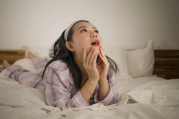 Lifestyle Porträt einer jungen schönen und süßen asiatischen Chinesin im Bett, die sich glücklich und entspannt fühlt und süße Pyjamas trägt und den faulen Sonntagmorgen zu Hause genießt — Stockfoto