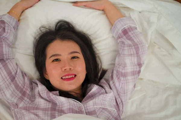 Образ жизни портрет молодой красивой и сладкой азиатской китаянки в постели, чувствуя себя счастливым и расслабленным носить милые пижамы наслаждаясь ленивым воскресным утром дома — стоковое фото