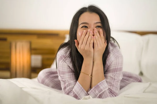 Lifestyle Porträt einer jungen schönen und süßen asiatischen Chinesin im Bett, die sich glücklich und entspannt fühlt und süße Pyjamas trägt und den faulen Sonntagmorgen zu Hause genießt — Stockfoto