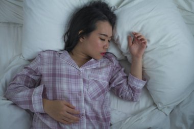 20 'li yaşlarındaki güzel ve tatlı Asyalı Koreli kızın hayat tarzı portresi. Evde tek başına uyur, rahat bir şekilde pijamalarıyla yatar, mutlu ve rahat bir şekilde dinlenir. 