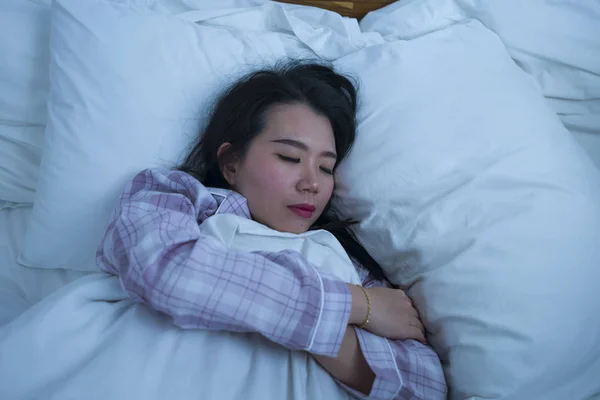 Potret gaya hidup gadis muda cantik dan manis dari Asia berumur 20-an sendirian di rumah tidur santai mengenakan piyama berbaring di tempat tidur bahagia dan nyaman beristirahat — Stok Foto