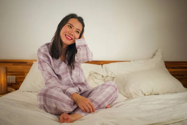 Lifestyle-Porträt einer jungen schönen und süßen asiatischen Koreanerin im Bett, die sich glücklich und entspannt fühlt und süße Pyjamas trägt und den faulen Sonntagmorgen zu Hause genießt — Stockfoto