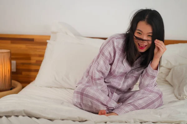 Lifestyle-Porträt einer jungen schönen und süßen asiatischen Koreanerin im Bett, die sich glücklich und entspannt fühlt und süße Pyjamas trägt und den faulen Sonntagmorgen zu Hause genießt — Stockfoto