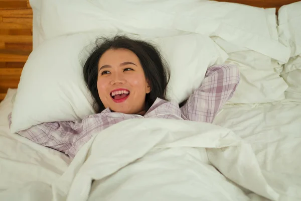 침대에 누워 있는 젊고 아름답고 달콤 한 동양인 여성 이 일요일 아침 집에서 게으름을 피우며 귀여운 잠옷을 입고 행복하고 편안 한 기분으로 생활하는 모습 — 스톡 사진