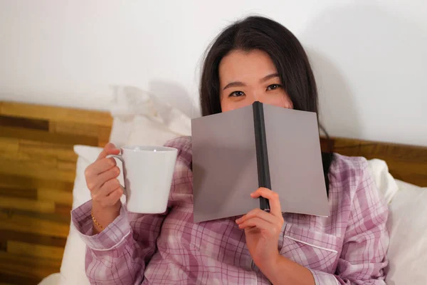 Junge schöne und süße asiatische Koreanerin im Bett lesen Buch Roman glücklich und verspielt fühlen oder zu Hause studieren in niedlichen Pyjama suchen gemütlich und heimelig — Stockfoto