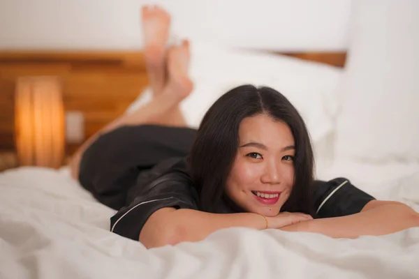Joven hermosa y dulce mujer coreana asiática en la cama sintiéndose feliz y relajado usando camisón lindo disfrutando perezoso domingo por la mañana en casa jugando acogedor — Foto de Stock