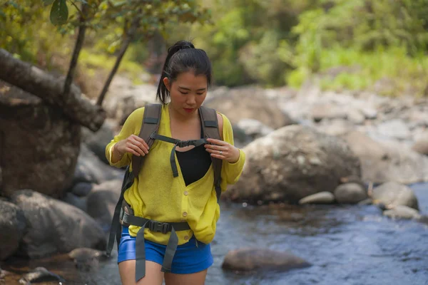 아름답고 행복 한 젊은 아시아인 여자가 여행 가방을 들고 강을 건너는 산위를 걷고 있다. — 스톡 사진