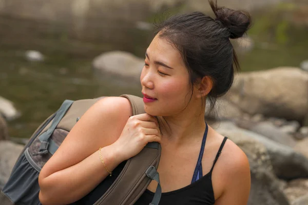 Ao ar livre retrato de jovem bonita e feliz asiática japonesa mulher carregando mochila trekking em montanhas cruzando rio desfrutando de férias natureza e ambiente fresco — Fotografia de Stock