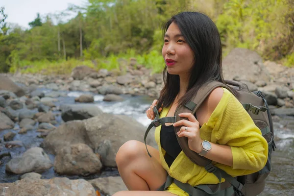Νεαρή όμορφη και ευτυχισμένη ασιατική κινεζική γυναίκα μεταφέρουν σακίδιο πεζοπορία στα βουνά διασχίζοντας ποτάμι απολαμβάνοντας φύση διακοπών και φρέσκο περιβάλλον πεζοπορία χαρούμενα — Φωτογραφία Αρχείου