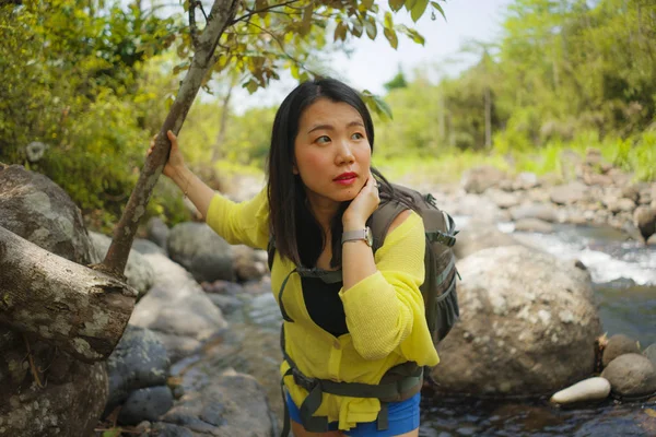 아름답고 행복 한 젊은 아시아 여자가 여행 가방을 들고 강을 건너는 산위를 걷고 있다. — 스톡 사진