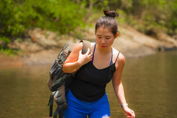 年轻、美丽、快乐的亚裔妇女背着背包徒步穿越高山过河，享受着节日的自然与新鲜的环境，愉快地徒步旅行 — 图库照片