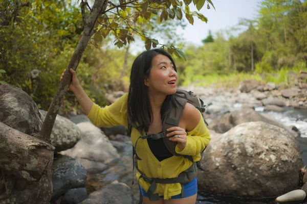 아름답고 행복 한 젊은 아시아 여성, 강을 건너는 산에서 배낭을 메고 여행하며 휴가를 즐기며 신선 한 환경을 즐기는 모습 — 스톡 사진
