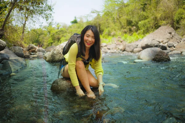 Jovem bela e feliz asiático japonês mulher carregando mochila trekking em montanhas cruzando rio apreciando férias natureza e ambiente fresco caminhadas alegre — Fotografia de Stock