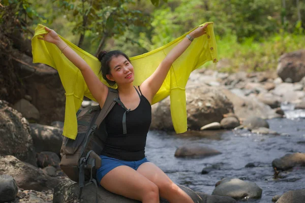 Joven hermosa y feliz asiática japonesa mujer llevando mochila trekking en montañas cruzando río disfrutando de vacaciones naturaleza y ambiente fresco senderismo alegre — Foto de Stock