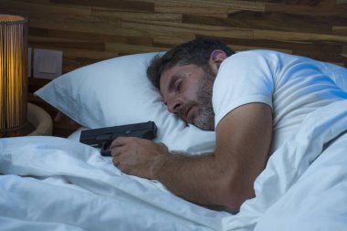 Yatakta uyuyan, silahlı, paranoyak ve paranoyak Amerikalı bir adamın gece portresi. Paranoya ve nefsi müdafaa konseptiyle eve zorla girilmesinden korkuyor.