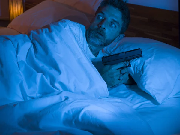 침대에 누워 있는 스트레스받고 편집증적 인 미국 남자의 야영 사진 침입자가 예상되는 불안 한 편집증 환자 주위에서 총을 들고 잠을 이룰 수없었다 — 스톡 사진