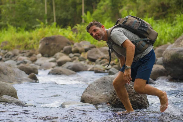 Ung glad och attraktiv man med resa ryggsäck vandring i floden på skogen känsla fri njuta av naturen och fräsch miljö på sommaren vandring resa — Stockfoto