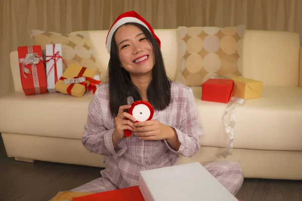 Χριστουγεννιάτικο πορτρέτο lifestyle διακοπές των νέων όμορφη και ευτυχισμένη ασιατική ιαπωνική γυναίκα σε Σάντα καπέλο ενθουσιασμένοι περιτύλιγμα Χριστούγεννα δώρα συσκευασίας με χαρτί — Φωτογραφία Αρχείου