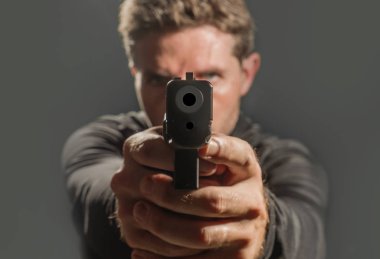 Çekici tetikçi ya da özel ajan silahı doğrudan kameraya doğrultmuş Hollywood tarzı gizli servis tarzı bir filmde izole edilmiş.