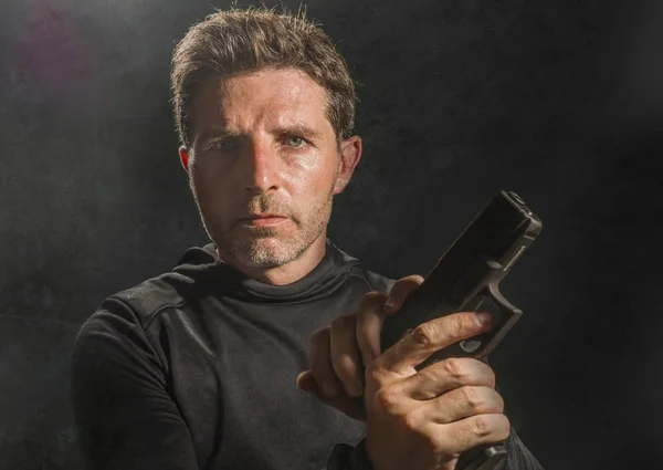 Actionporträtt av seriös och attraktiv torped eller specialagent man med pistol ladda om vapnet isolerad på mörk bakgrund i underrättelsetjänsten Hollywood stil film — Stockfoto