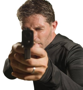  Ciddi ve çekici tetikçinin aksiyon portresi ya da özel ajan elinde silahla Hollywood tarzı bir filmde kameraya çevrilmiş stüdyo arkaplanından izole edilmiş.