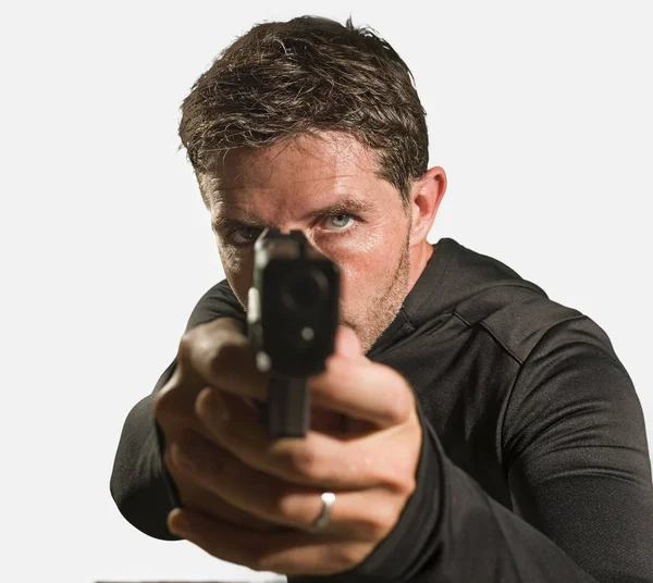 Action-Portrait eines ernsthaften und attraktiven Hitman oder Special Agent Mann mit Waffe, der die Handfeuerwaffe in die Kamera richtet, im Hollywood-Stil, isoliert auf Studiohintergrund — Stockfoto
