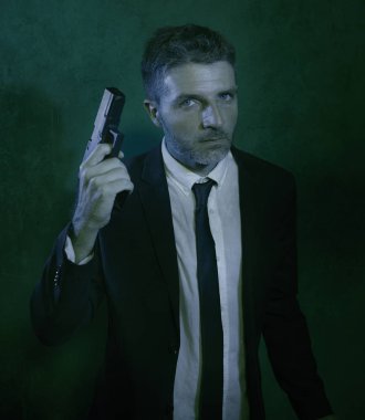Man pointing handgun dramatic action portrait of attractive special agent or police officer aiming with gun in suit and tie holding the weapon serious in law enforcement
