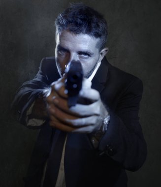 Man pointing handgun dramatic action portrait of attractive special agent or police officer aiming with gun in suit and tie holding the weapon serious in law enforcement