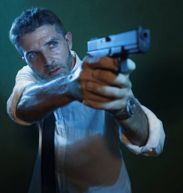 Man pointing handgun dramatic action portrait of attractive special agent or police officer aiming with gun in white shirt and tie holding the weapon serious in law enforcement