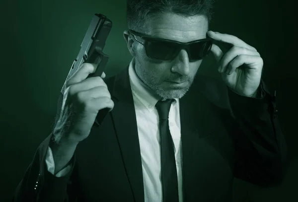 Muž mířící pistolí dramatický akční portrét atraktivního zvláštního agenta nebo policistu mířícího pistolí v obleku a kravatě držícího zbraň vážnou při prosazování zákona — Stock fotografie