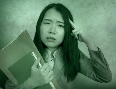 corporate business stress portrait of young attractive upset and stressed executive Asian Korean woman tired and unhappy holding paperwork overwhelmed